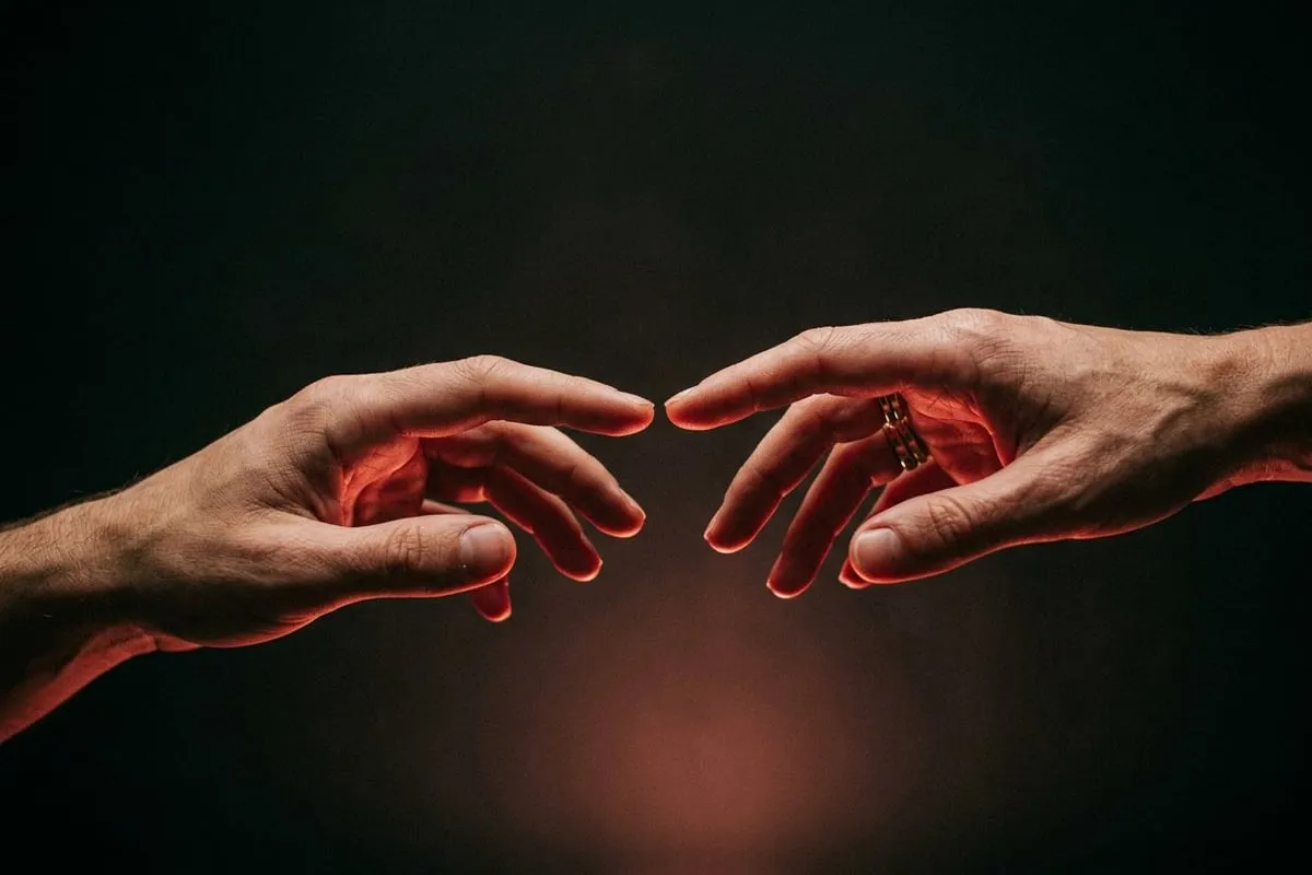 兩手指尖幾乎相觸卻未碰，暖玫瑰光從下方照亮皮膚，象徵多巴胺的渴望