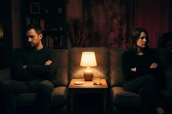 情侶吵架後坐在沙發兩端，沉默冷戰