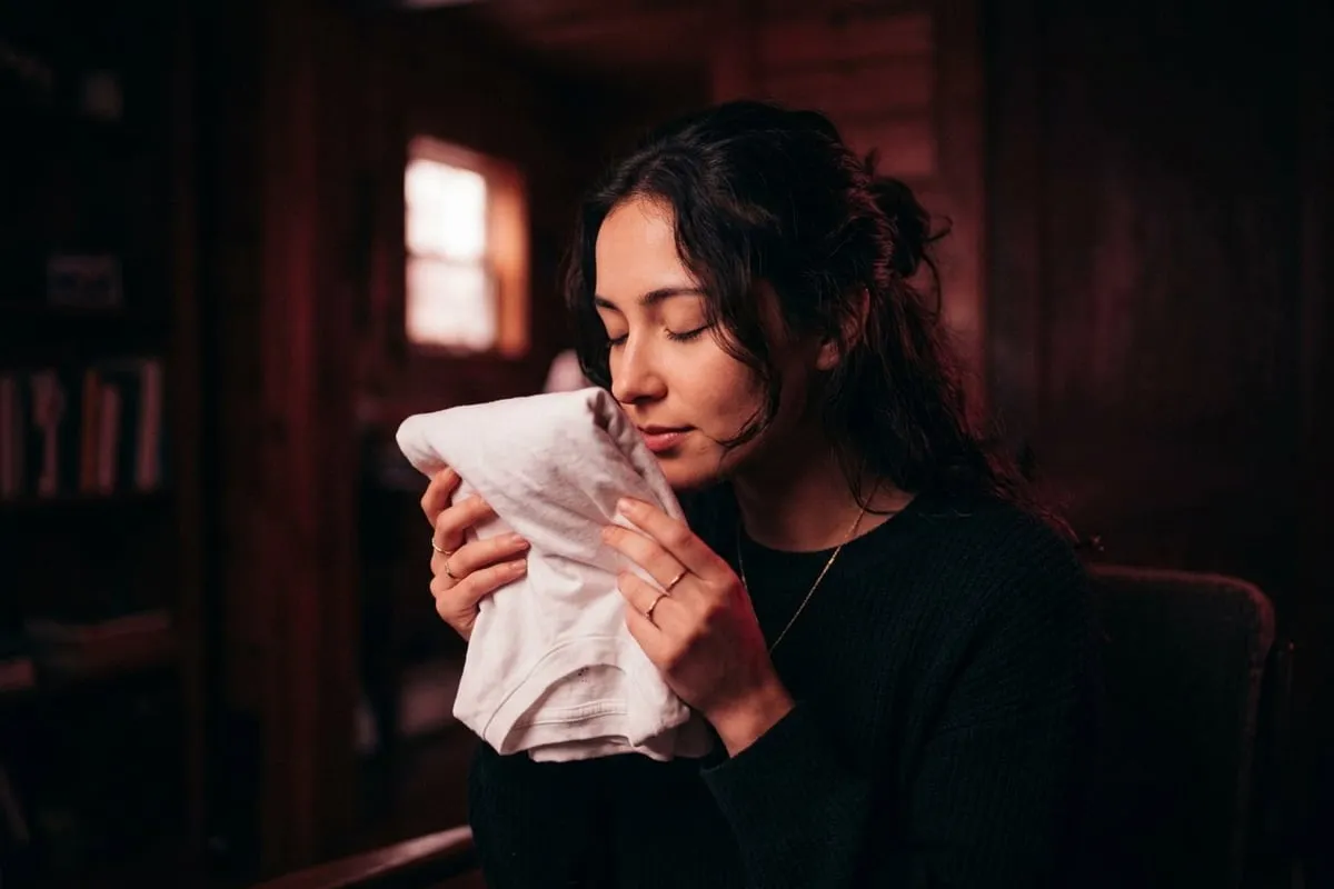 女性閉眼輕嗅T恤，感受體味的吸引力